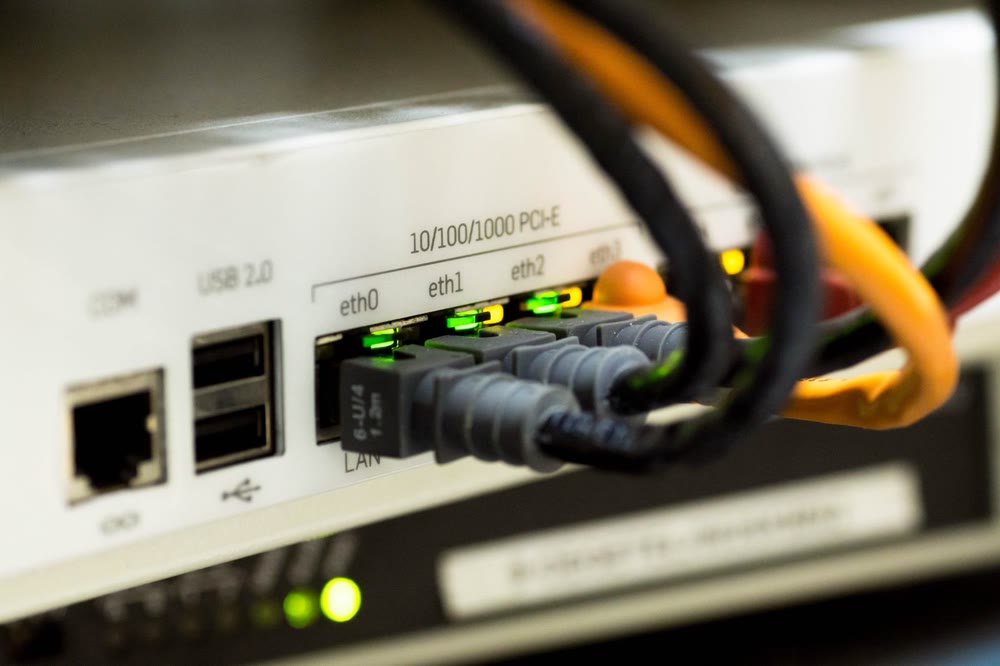 ネットワーク機器のポートにLANケーブルが接続され、ランプが点灯している様子