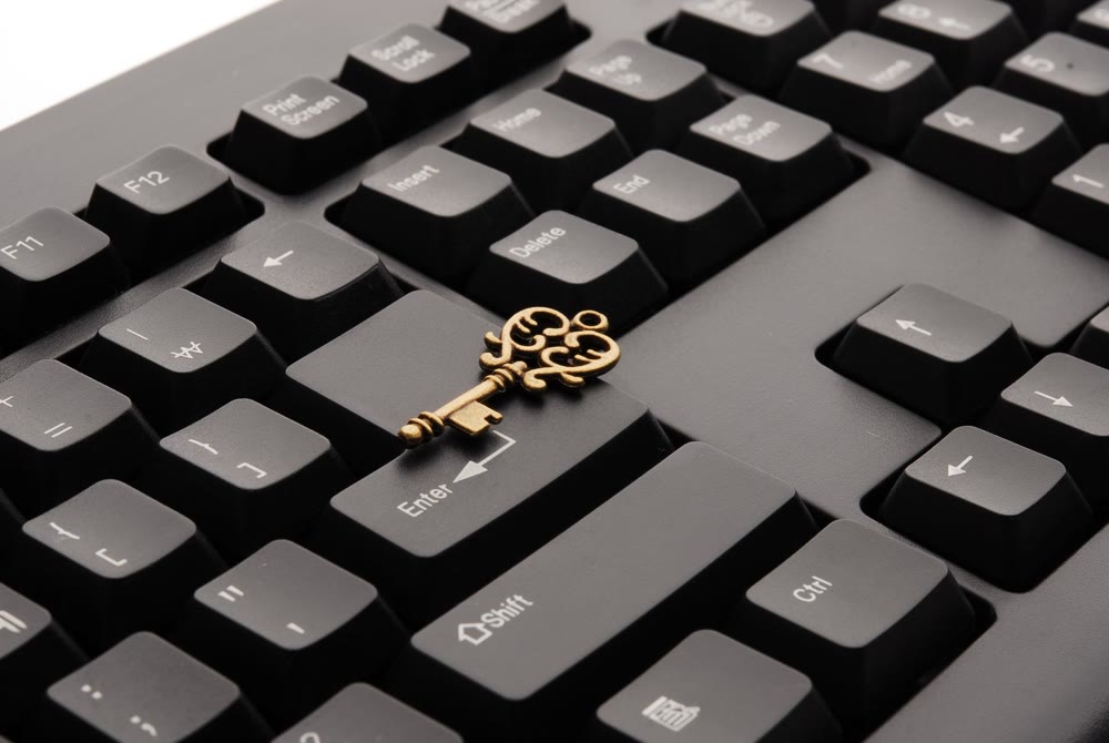 黒いキーボードのEnterキー付近に置かれた装飾的な金色の鍵